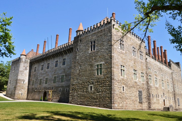 a stone castle next to a brick building with Huntingtower Castle in the background