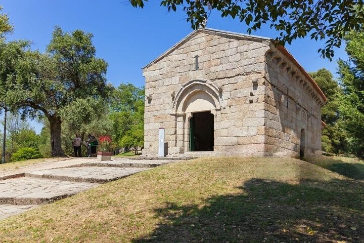 a small clock tower in front of a brick building
